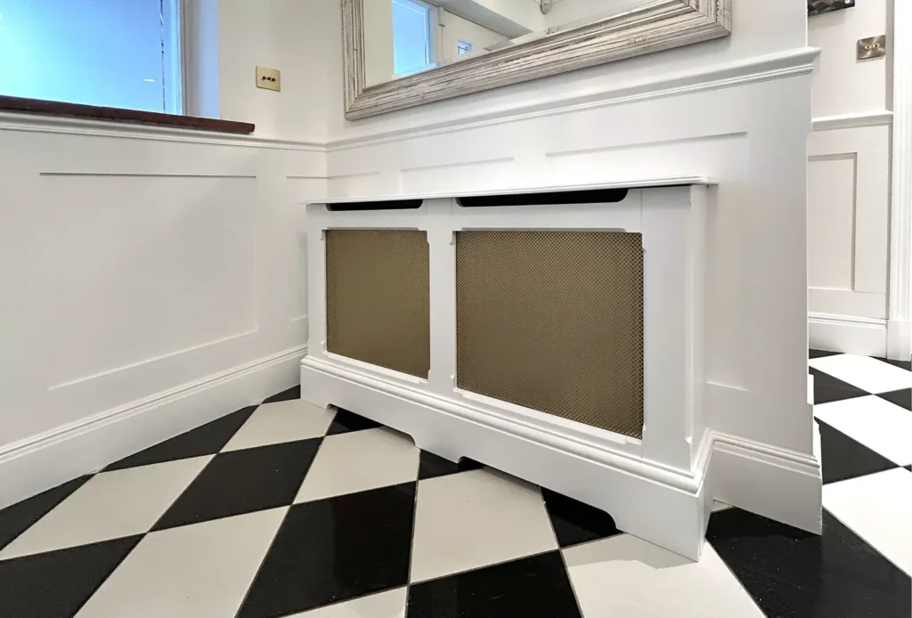 Restored and decorated radiator on checkerboard floor in entrance area after damp restoration work.