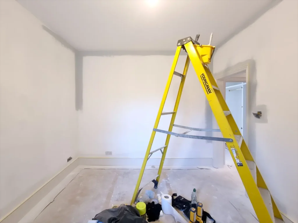 Damp proofing prject at inspection stage with yellow ladder in the middle of the room.